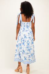 woman wearing a blue and white floral maxi dress with tie shoulder straps and a smocked back