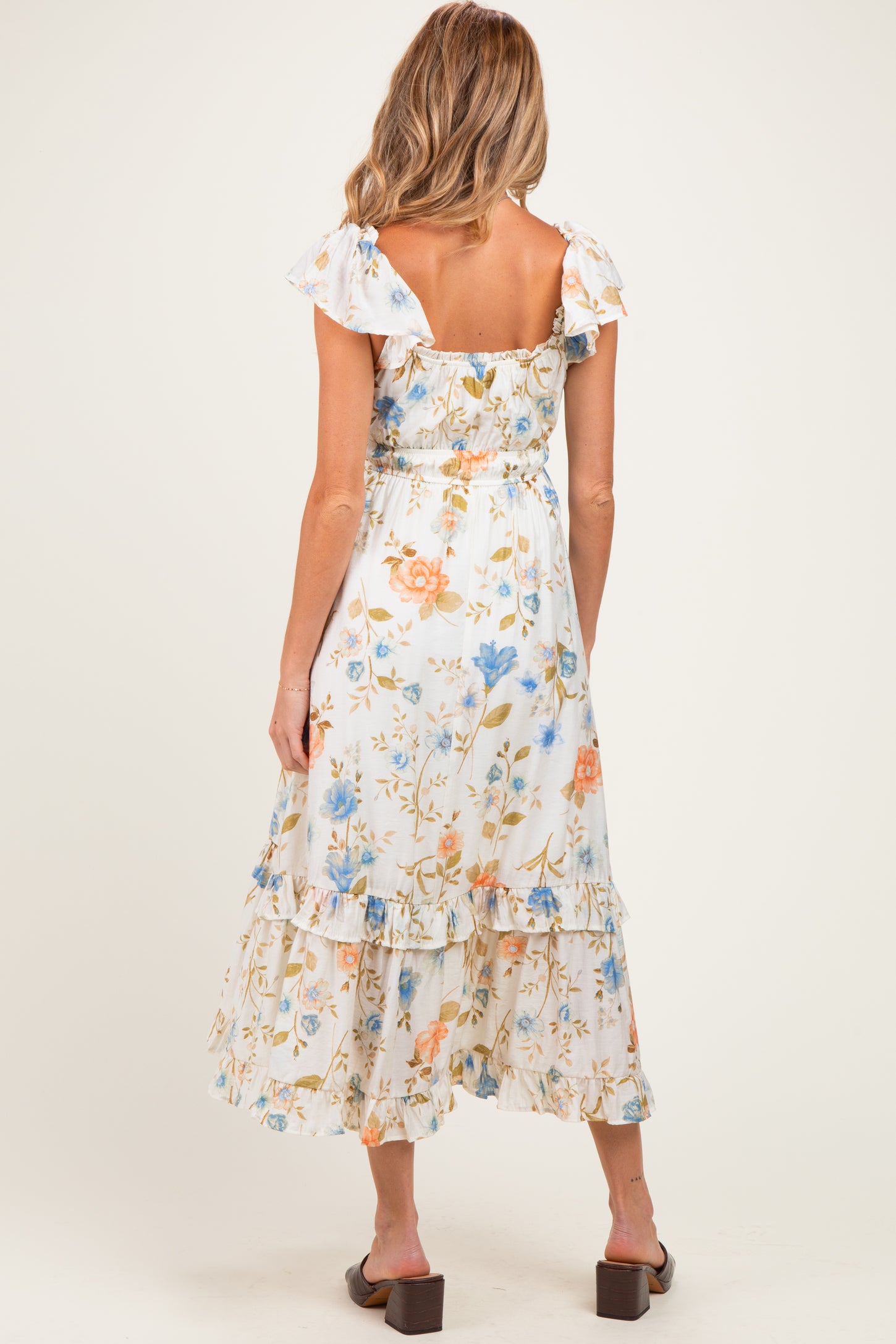 woman wearing a floral print maternity maxi dress with ruffle sleeves and tiered hem