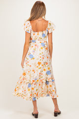 woman wearing a floral maternity maxi dress with ruffled sleeves and tiers, showing her baby bump from the back