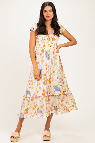 woman wearing a white floral midi dress with puff sleeves and tiered ruffles