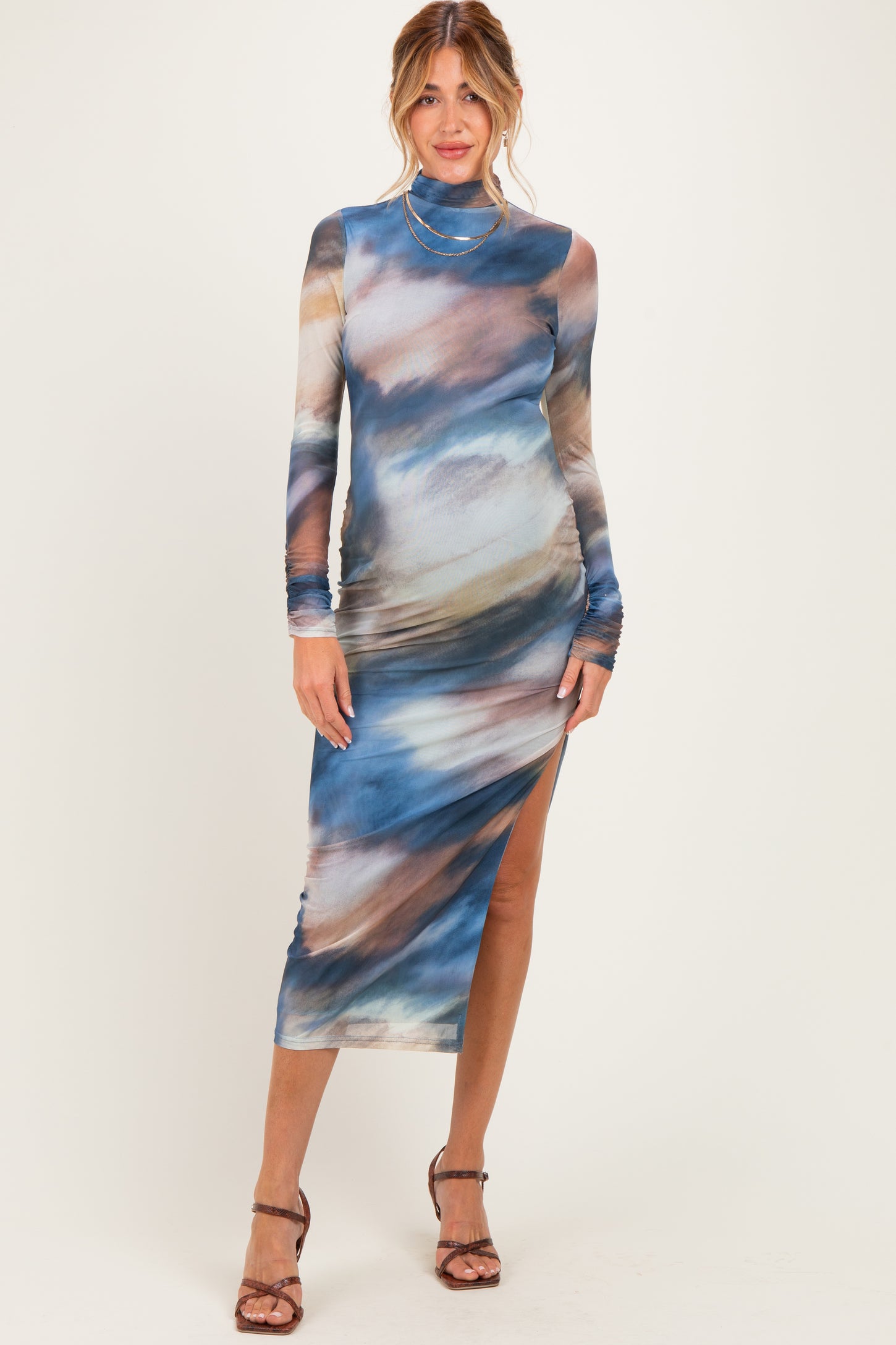 woman wearing a long sleeve blue and multi-colored maternity dress with a side slit and slim fit
