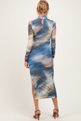 woman wearing a long sleeve blue and brown patterned maternity dress with a back keyhole detail and slit