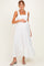 woman wearing a white maternity dress with ruffled straps and a tiered hem, holding her baby bump