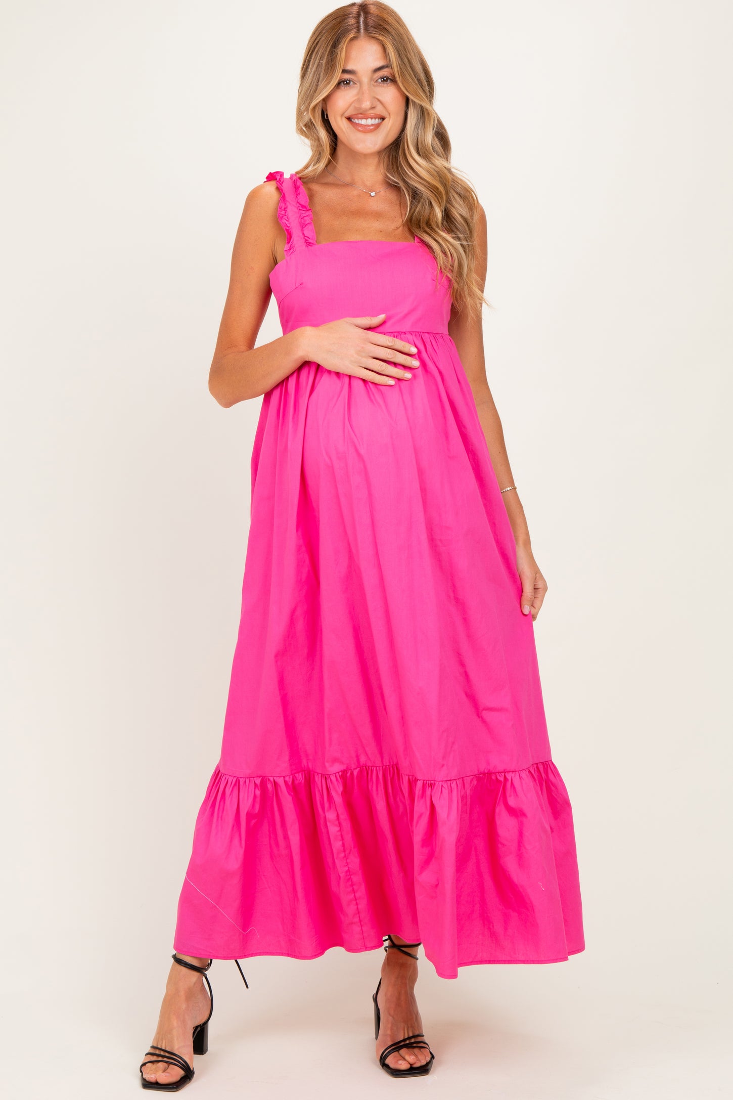 woman wearing a bright pink maternity maxi dress with ruffled straps and a baby bump visible