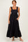 woman wearing a black maxi dress with ruffled straps and a tiered skirt.