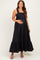woman wearing a black maternity maxi dress with ruffled straps and a flowing skirt, holding her baby bump
