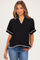 woman wearing a black short sleeve maternity top with white trim and a relaxed fit