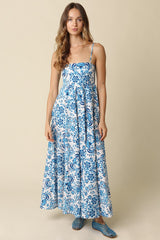 woman wearing a blue and white floral maxi dress with thin straps and a flared skirt
