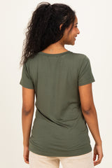 woman wearing an olive green short sleeve maternity top, seen from the back