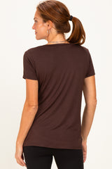 woman wearing a dark brown short sleeve t-shirt, view from the back, paired with black leggings