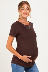 woman wearing a brown short sleeve maternity top and holding her baby bump