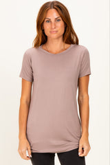 woman wearing a taupe short sleeve t-shirt with a rounded neckline and relaxed fit