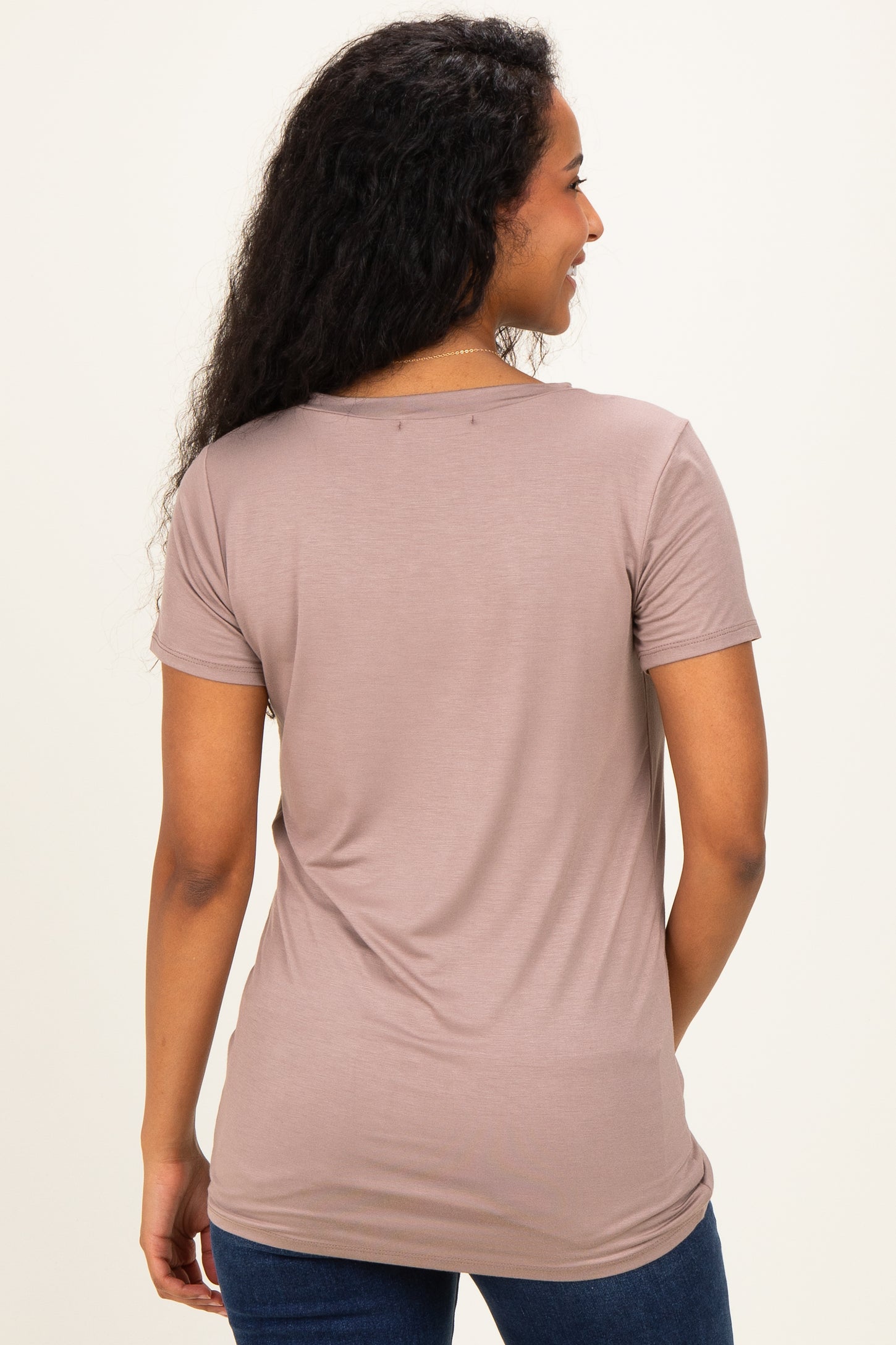 woman wearing a light taupe short sleeve maternity top, showing the back view and made from soft, stretchy fabric