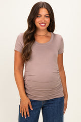 woman wearing a dusty rose short sleeve maternity top with gathered sides and a visible baby bump