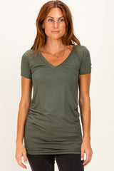 woman wearing an olive green short sleeve v-neck top with gathered side detailing and slim fit