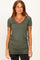 woman wearing an olive green short sleeve v-neck top with gathered side detailing and slim fit