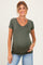 woman wearing a green short sleeve maternity top with ruching and showing her baby bump