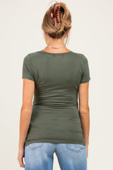 woman wearing a dark green maternity t-shirt with a fitted style and ruching at the sides