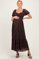 woman wearing a brown lace maternity maxi dress with puff sleeves and a baby bump