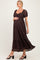 woman wearing a brown lace maternity dress with puff sleeves and a flowing skirt, showcasing her baby bump