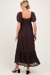 woman wearing a brown lace maternity maxi dress with puff sleeves and a tiered hem