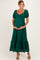 woman wearing a dark green lace maternity dress with puff sleeves and a flowing skirt, holding her baby bump