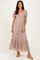 woman wearing a nude lace maxi dress with puff sleeves and a tiered skirt