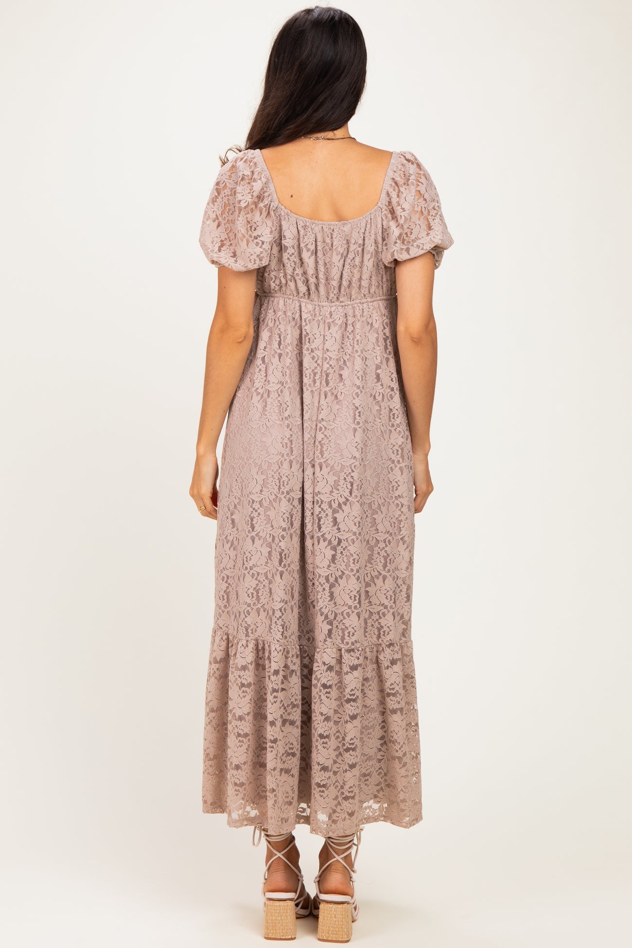 woman wearing a dusty rose lace maxi dress with puff sleeves and a tiered hem