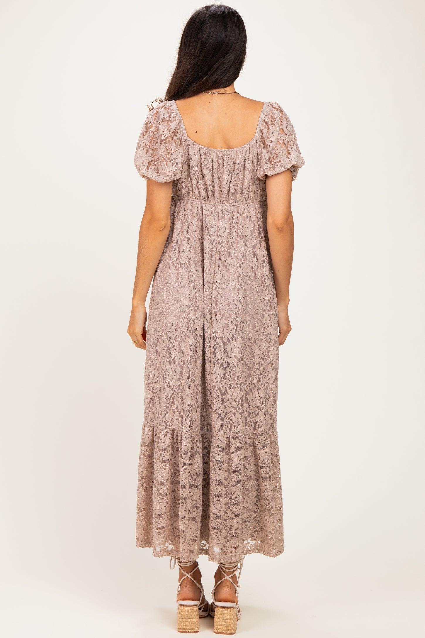 woman wearing a dusty rose lace maxi dress with puff sleeves and a tiered hem