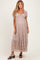 woman wearing a light brown lace maternity dress with puff sleeves and a tiered hem, showing her baby bump