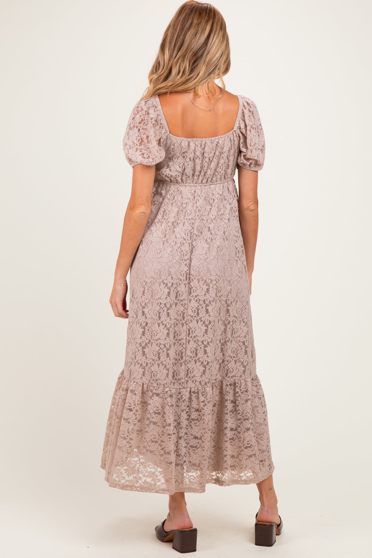 woman wearing a dusty rose lace maternity maxi dress with puff sleeves, photographed from the back