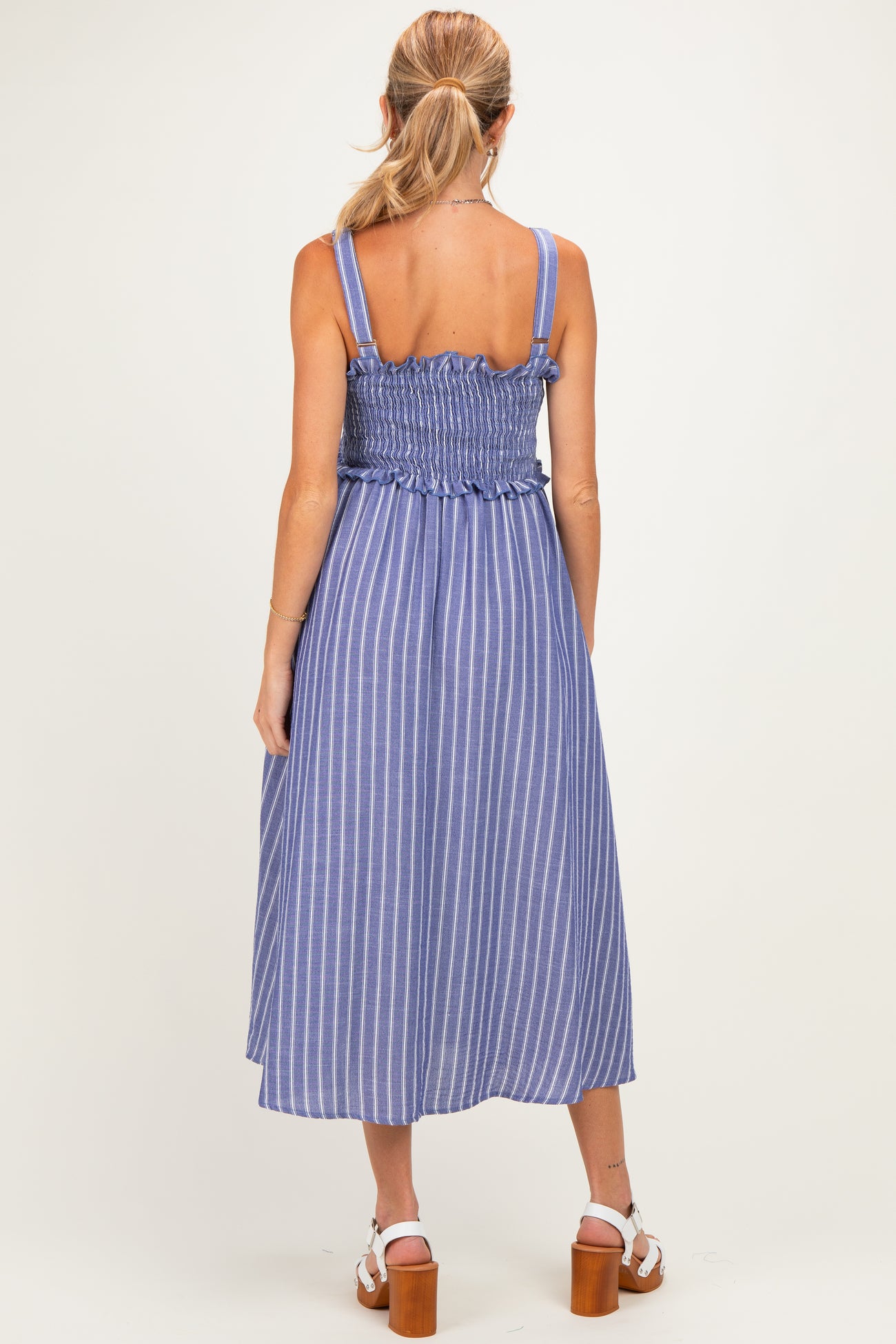 woman wearing a blue and white striped maternity dress with a smocked back and a flowy midi length