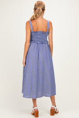 woman wearing a blue and white striped maternity dress with a smocked back and a flowy midi length