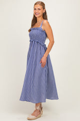 woman wearing a blue and white striped sundress with shirred bodice and spaghetti straps, paired with beige espadrille wedges