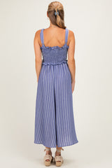 woman wearing a blue and white striped backless jumpsuit with smocked waist and wide legs