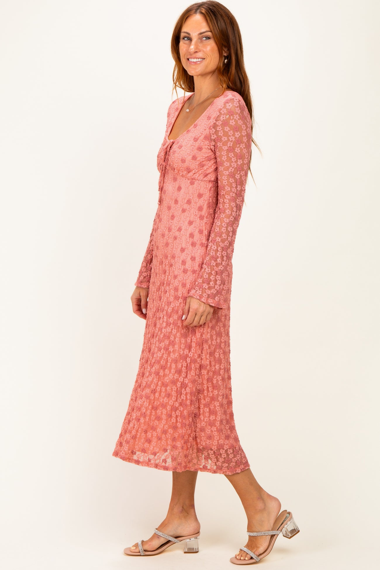 woman wearing a pink floral long sleeve midi dress with a v-neck and flared sleeves