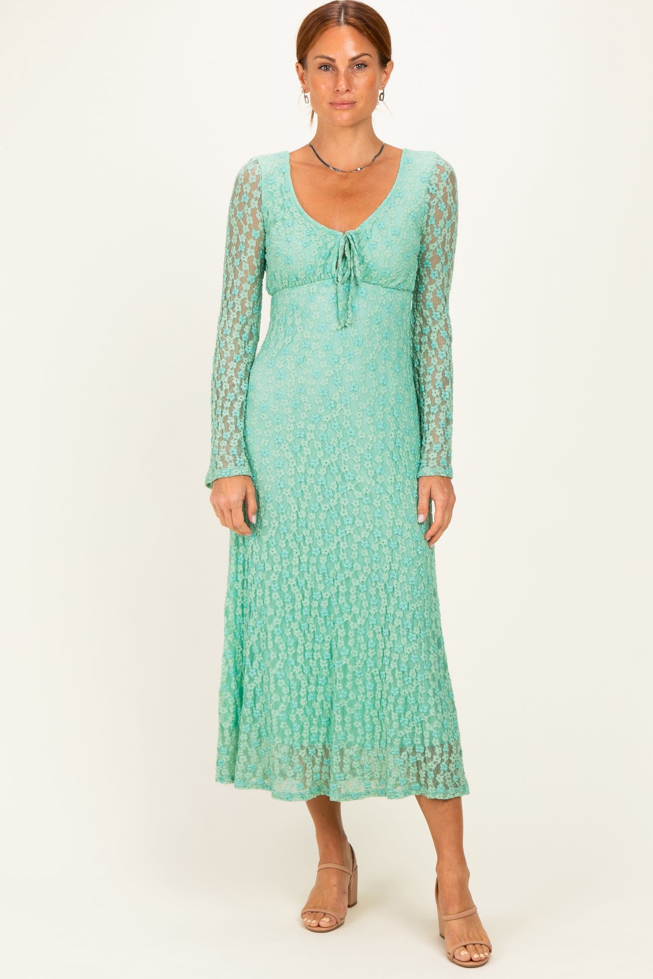 woman wearing a light green long sleeve maxi dress with a tie front and textured lace detail