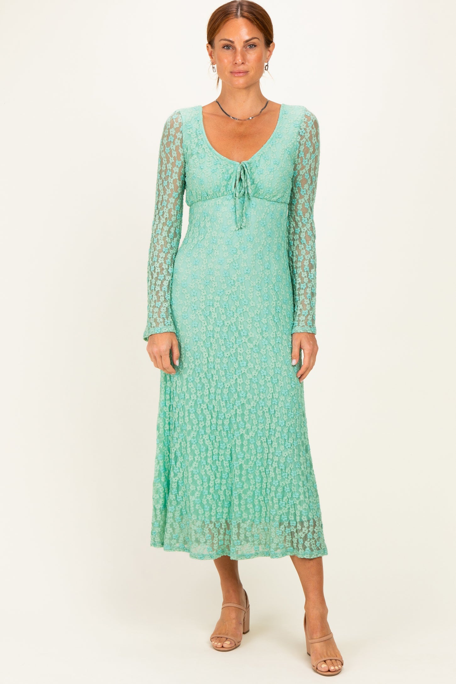 woman wearing a light green long sleeve maxi dress with a tie front and textured lace detail