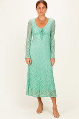 woman wearing a light green long sleeve maxi dress with a tie front and textured lace detail
