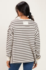 woman wearing a gray and white striped oversized sweater, shown from the back, with a relaxed fit and drop shoulder design
