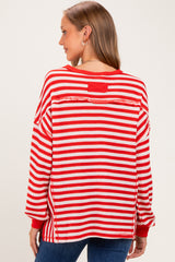 woman wearing a red and white striped maternity sweater with a relaxed fit and long sleeves