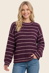 woman wearing a purple and white striped oversized sweater with long sleeves and a relaxed fit