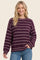 woman wearing a purple and white striped oversized sweater with long sleeves and a relaxed fit