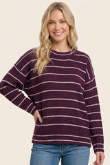 woman wearing a purple and white striped oversized sweater with a relaxed fit and long sleeves