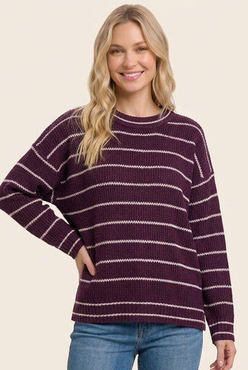 woman wearing a purple and white striped oversized sweater with a relaxed fit and long sleeves