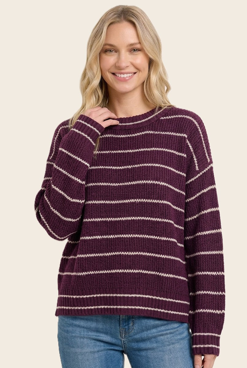 woman wearing a burgundy and cream striped oversized sweater with a relaxed fit and long sleeves