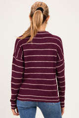 woman wearing a striped maroon maternity sweater with long sleeves and a relaxed fit, seen from the back
