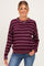 woman wearing a maroon striped maternity sweater with a relaxed fit and scoop neckline, smiling at the camera