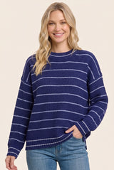 woman wearing a navy blue striped sweater with a relaxed fit and long sleeves, smiling at the camera