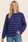 woman wearing a navy blue striped sweater with a relaxed fit and long sleeves, smiling at the camera